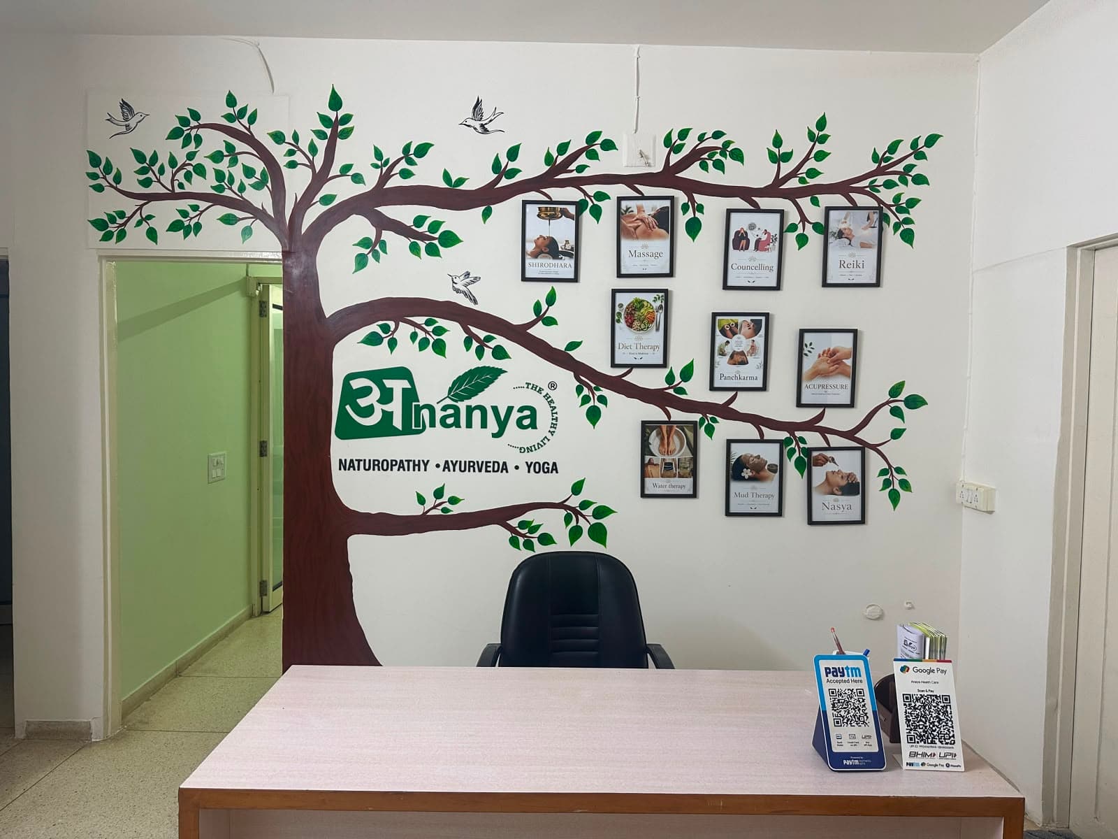 Ananya Naturopathy reception with the hand-painted healing tree